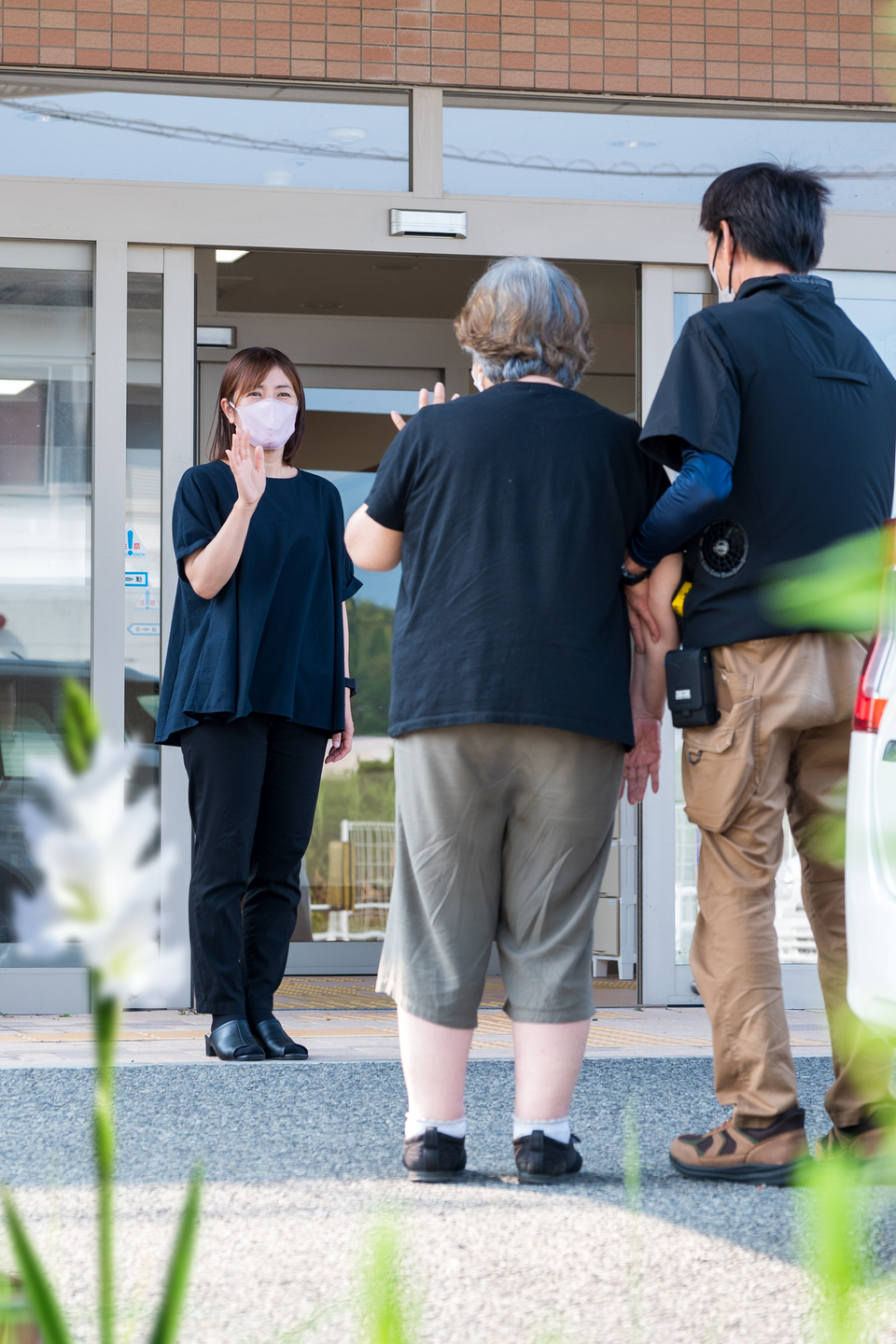 施設玄関で利用者を支える職員